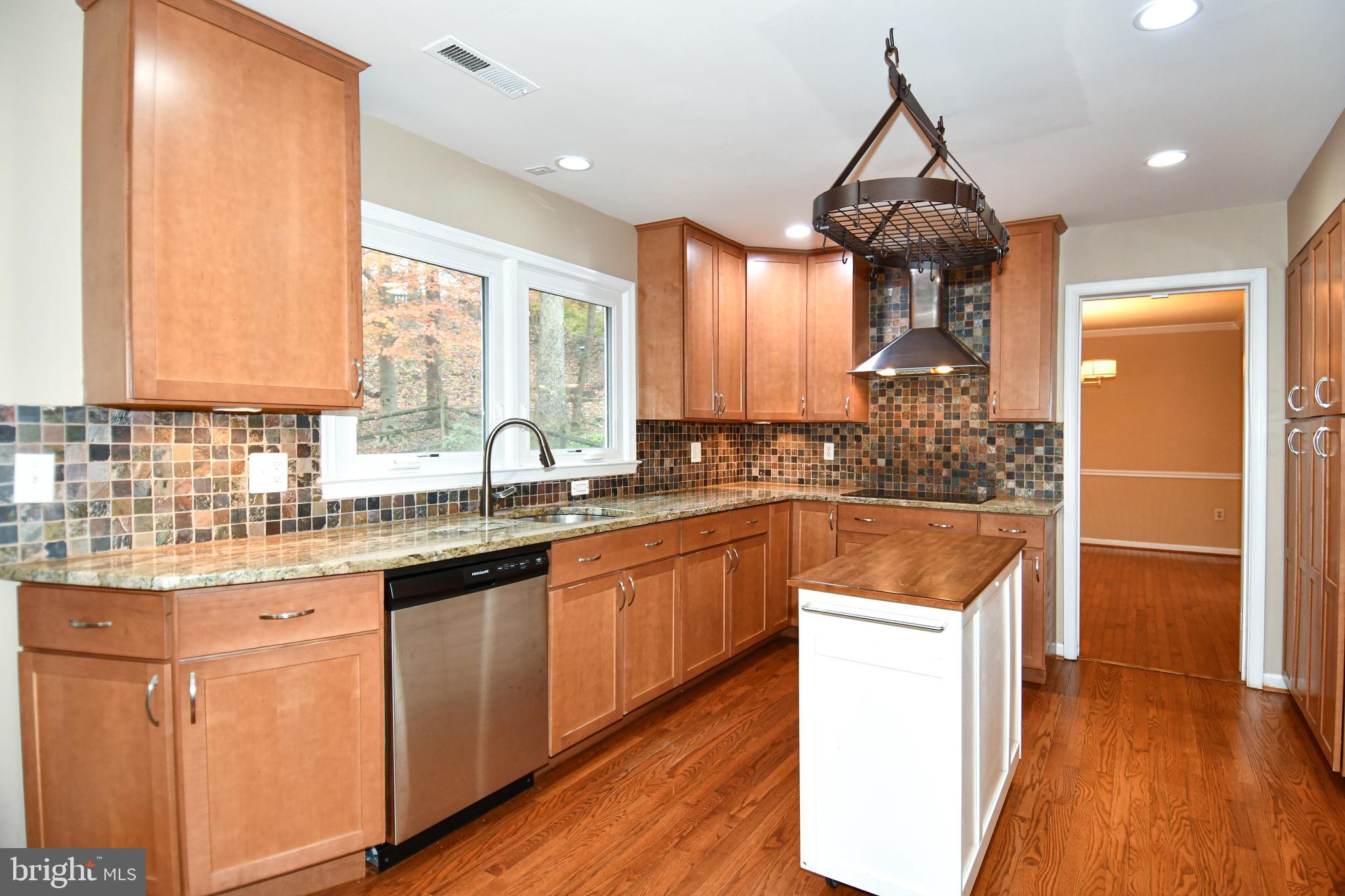 13135 Hutchinson Way Silver Spring, MD 20906 - Photo 21 of 64 a kitchen with stainless steel appliances granite countertop a sink a stove and a wooden floors