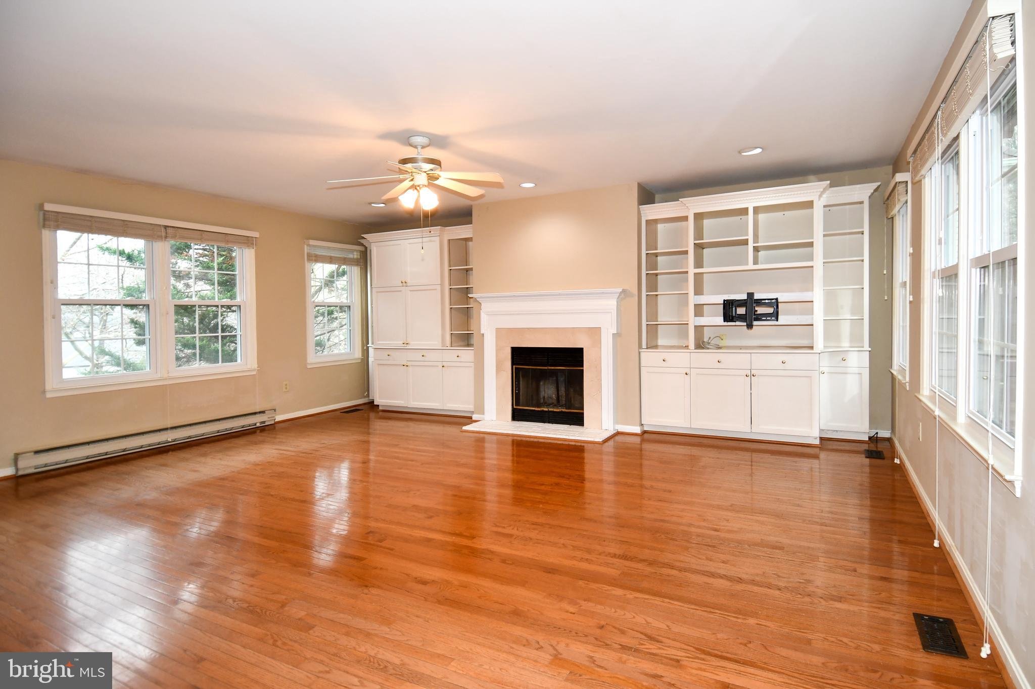 13135 Hutchinson Way Silver Spring, MD 20906 - Photo 8 of 64 an empty room with wooden floor fireplace and windows