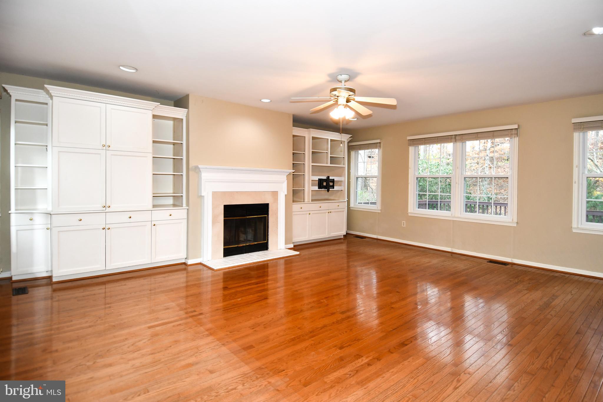 13135 Hutchinson Way Silver Spring, MD 20906 - Photo 10 of 64 an empty room with wooden floor fireplace and windows