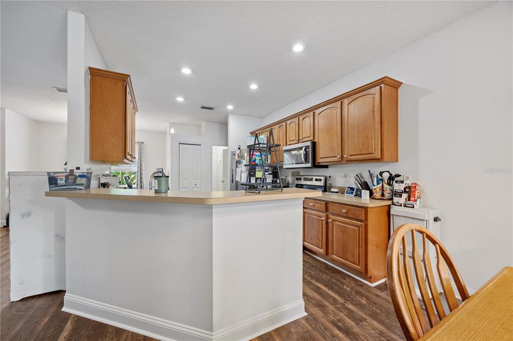 9312 Southwest 152nd Court Lake Butler, FL 32054 - Photo 11 of 37 a kitchen with stainless steel appliances granite countertop a refrigerator a stove a sink dishwasher and white cabinets with wooden floor