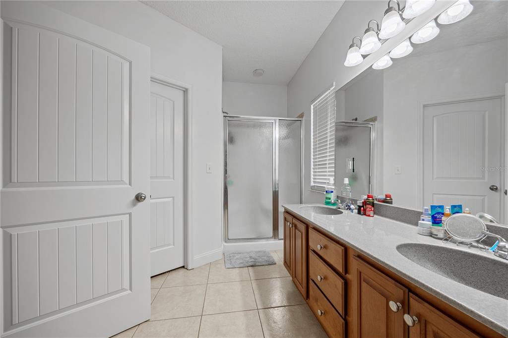 9312 Southwest 152nd Court Lake Butler, FL 32054 - Photo 16 of 37 a bathroom with a double vanity sink a mirror and a shower