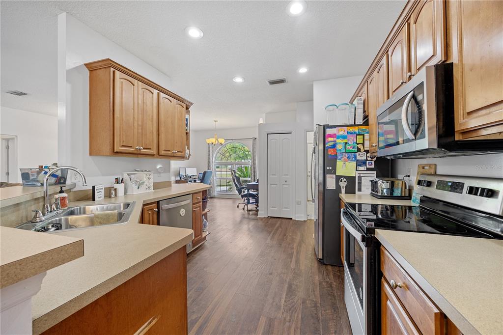 9312 Southwest 152nd Court Lake Butler, FL 32054 - Photo 9 of 37 a kitchen with stainless steel appliances granite countertop a refrigerator a stove top oven a sink dishwasher and white cabinets with wooden floor