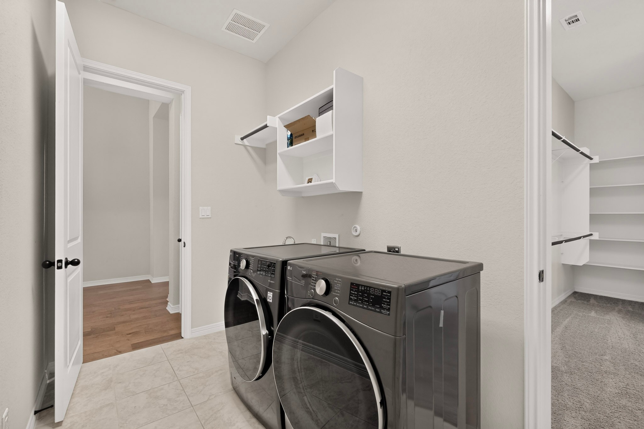 2433 La Mirada Street Leander, TX 78641 - Photo 12 of 25 A well-appointed utility room features abundant storage and modern laundry appliances.