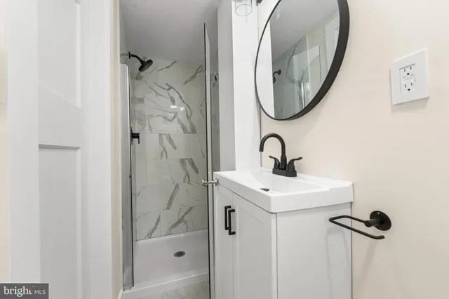 a bathroom with a sink and mirror with bathtub