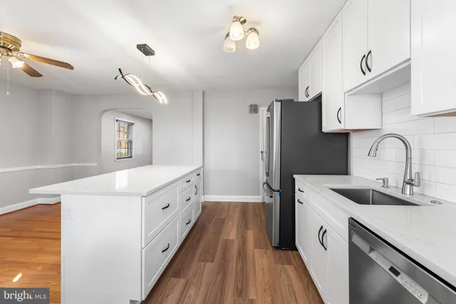 a large white kitchen with a sink a refrigerator and a stove
