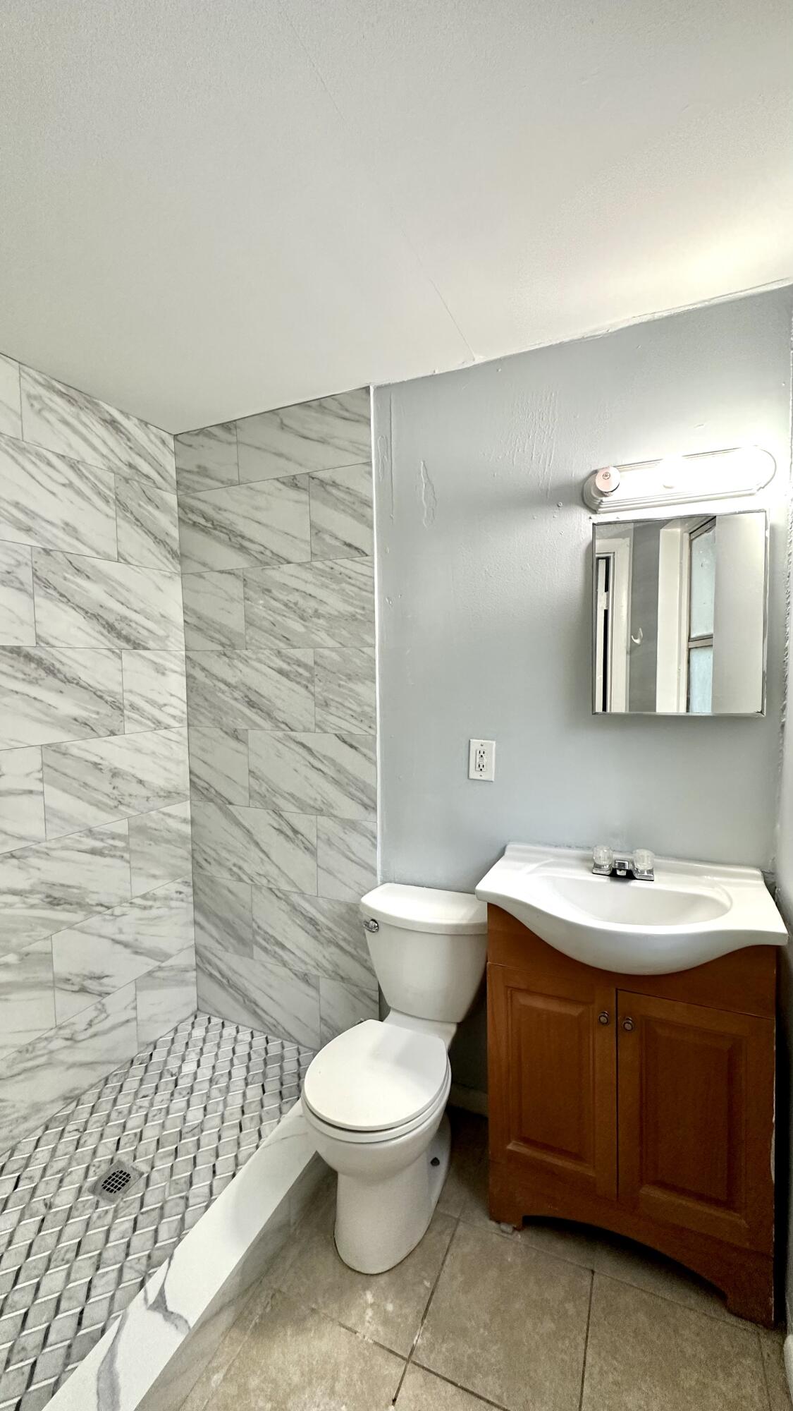 3804 Miller Avenue, Unit C West Palm Beach, FL 33405 - Photo 2 of 10 a bathroom with a toilet a sink and mirror