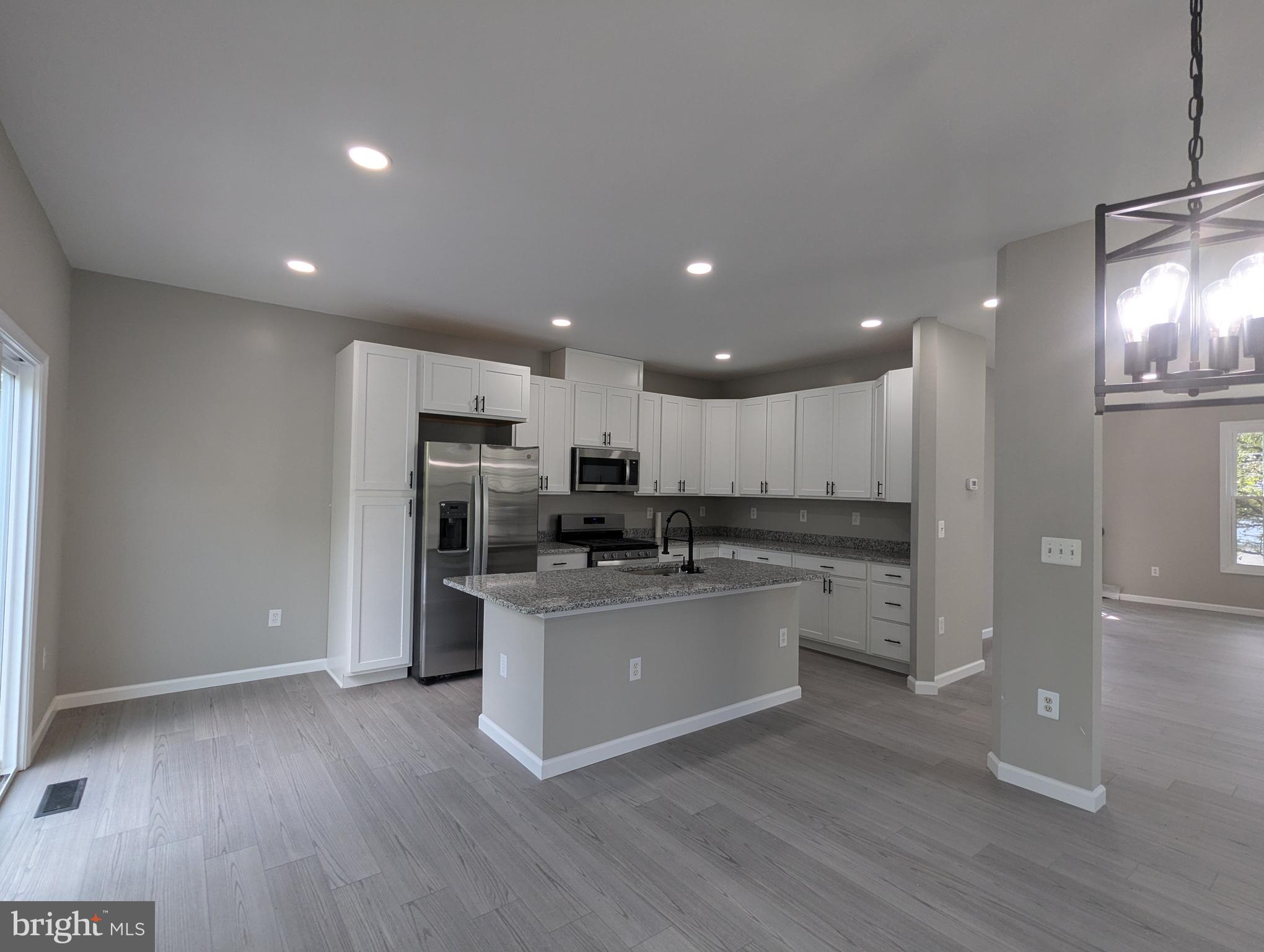 17415 Denali Place Dumfries, VA 22025 - Photo 1 of 55 a kitchen with stainless steel appliances kitchen island granite countertop a refrigerator and a stove top oven