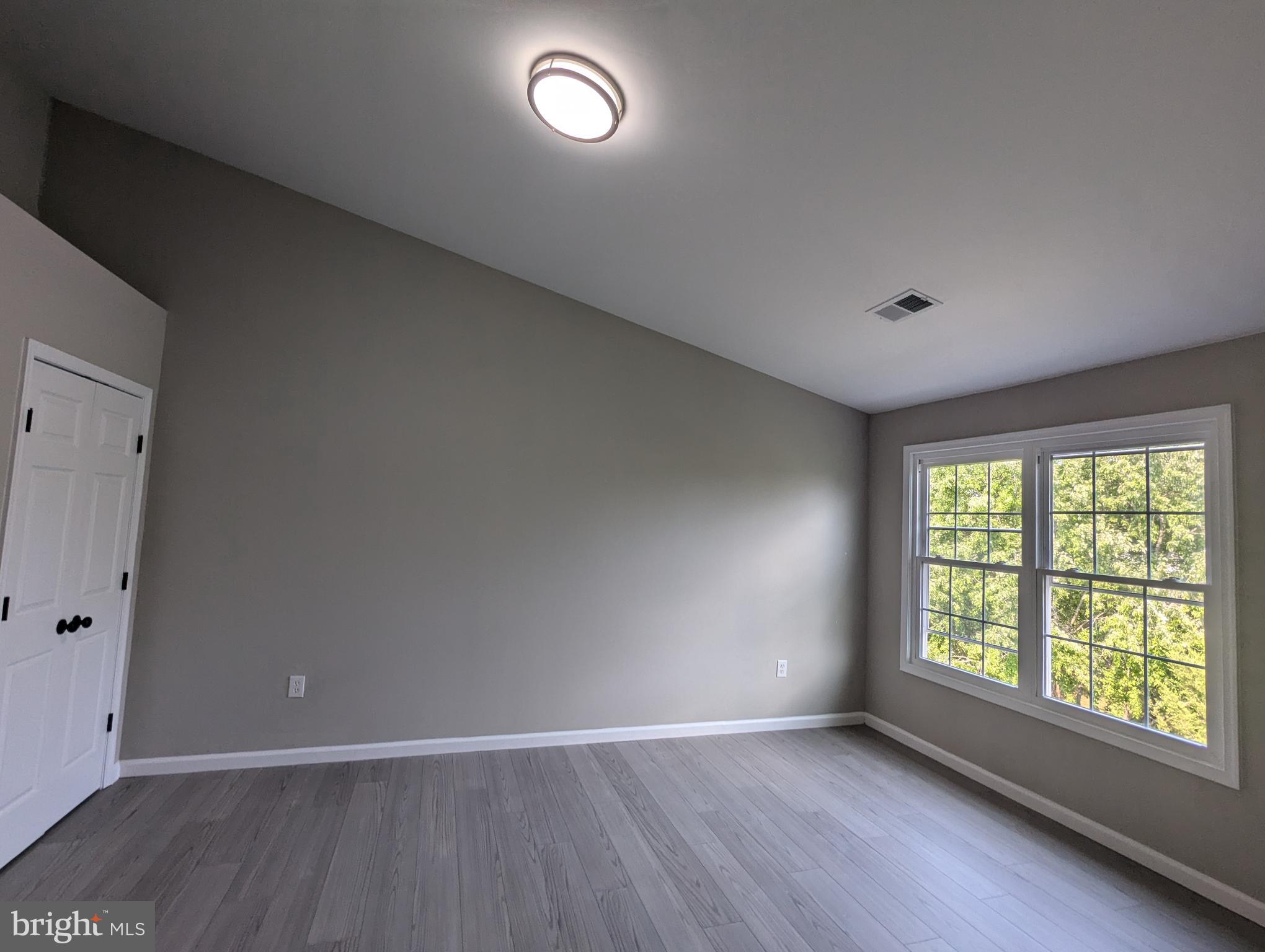17415 Denali Place Dumfries, VA 22025 - Photo 17 of 55 an empty room with wooden floor and windows