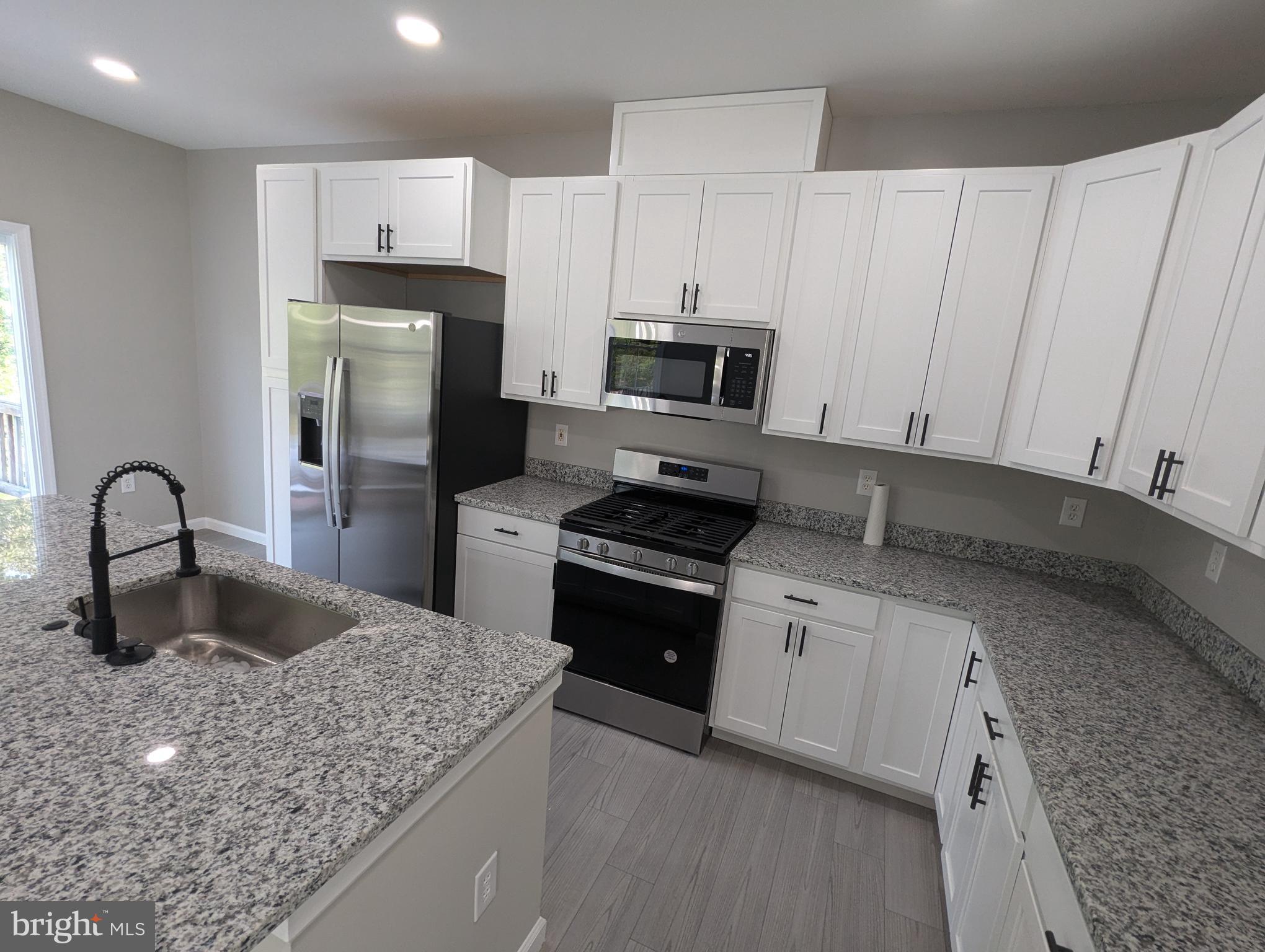 17415 Denali Place Dumfries, VA 22025 - Photo 2 of 55 a kitchen with kitchen island granite countertop a sink stainless steel appliances and cabinets