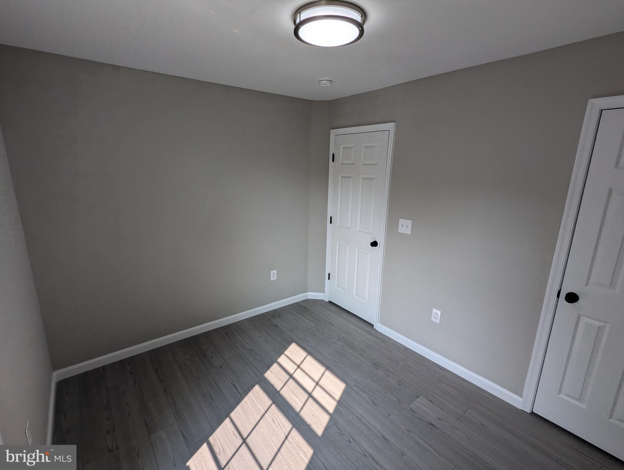 17415 Denali Place Dumfries, VA 22025 - Photo 22 of 55 an empty room with wooden floor and windows
