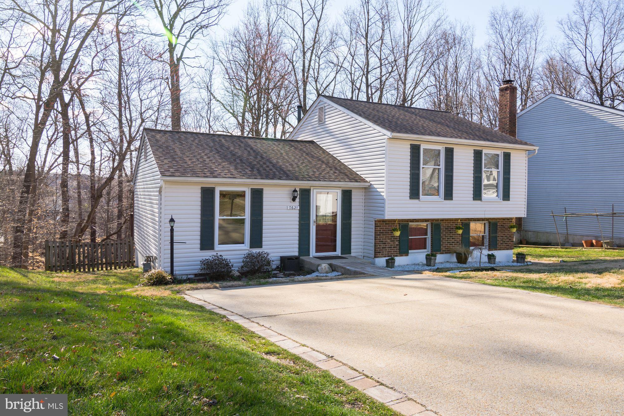 7621 Fallswood Way Lorton, VA 22079 - Photo 1 of 26 a front view of a house with a yard and trees