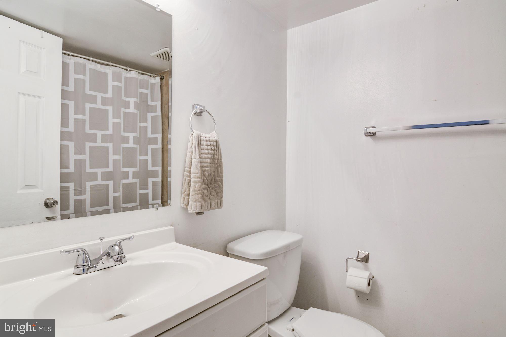 7621 Fallswood Way Lorton, VA 22079 - Photo 22 of 26 a bathroom with a sink mirror vanity and toilet