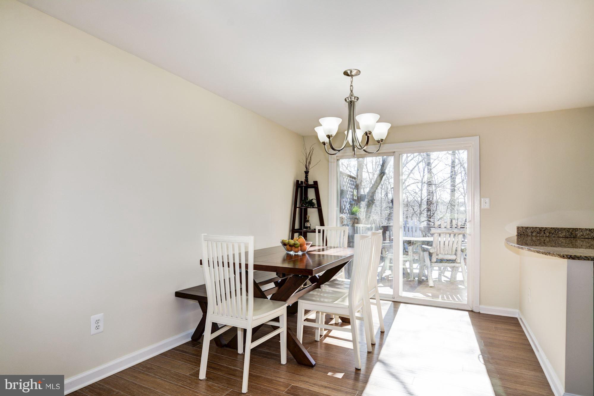 7621 Fallswood Way Lorton, VA 22079 - Photo 6 of 26 a dining room with chandelier and wooden floor