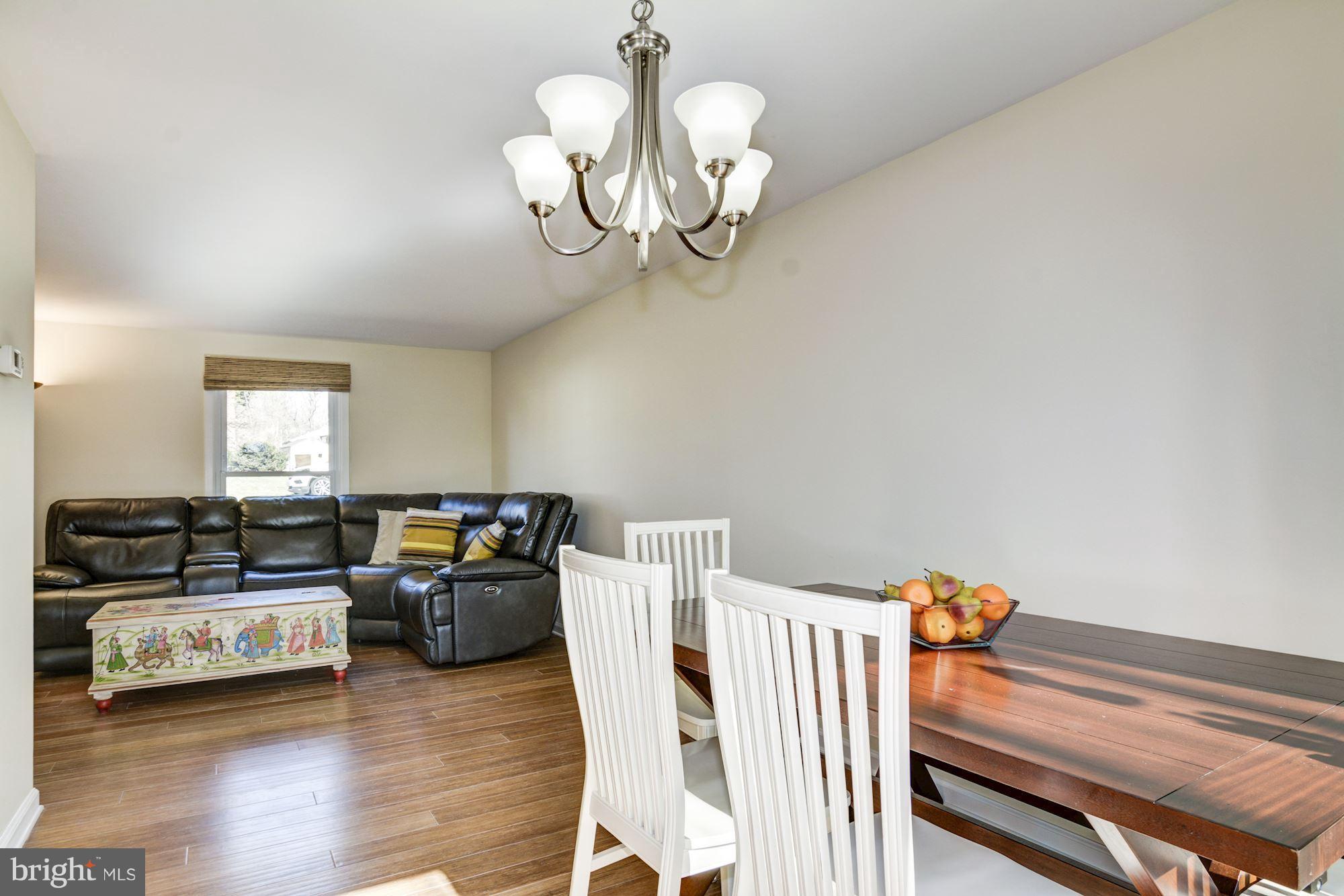 7621 Fallswood Way Lorton, VA 22079 - Photo 7 of 26 a view of a dining room with furniture a chandelier and wooden floor