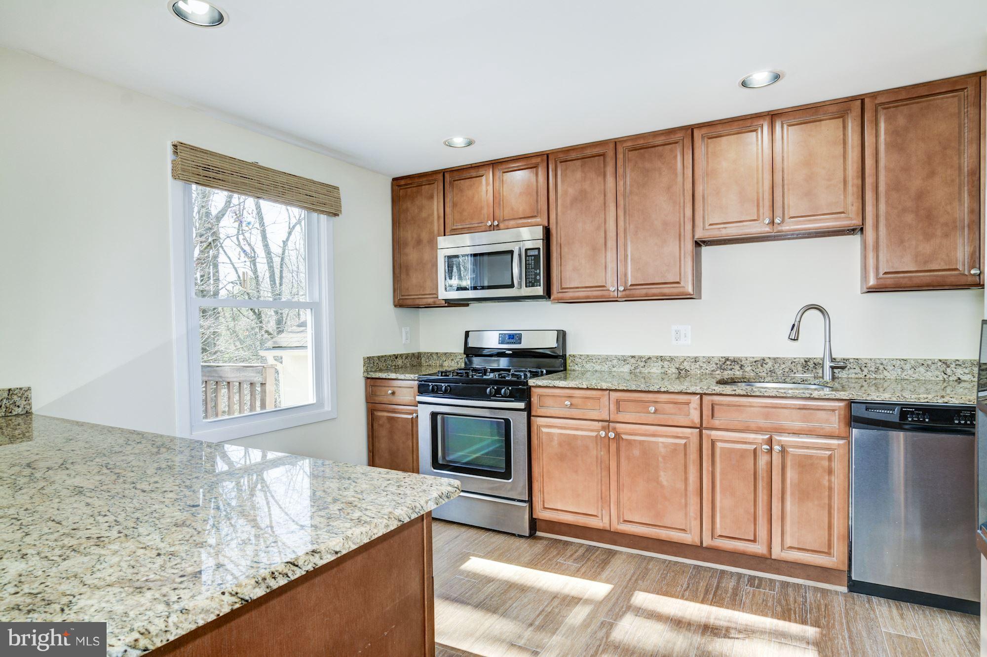 7621 Fallswood Way Lorton, VA 22079 - Photo 10 of 26 a kitchen with stainless steel appliances granite countertop a stove a sink and a microwave