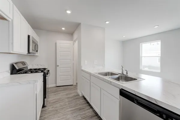 a kitchen with a sink stove and cabinets