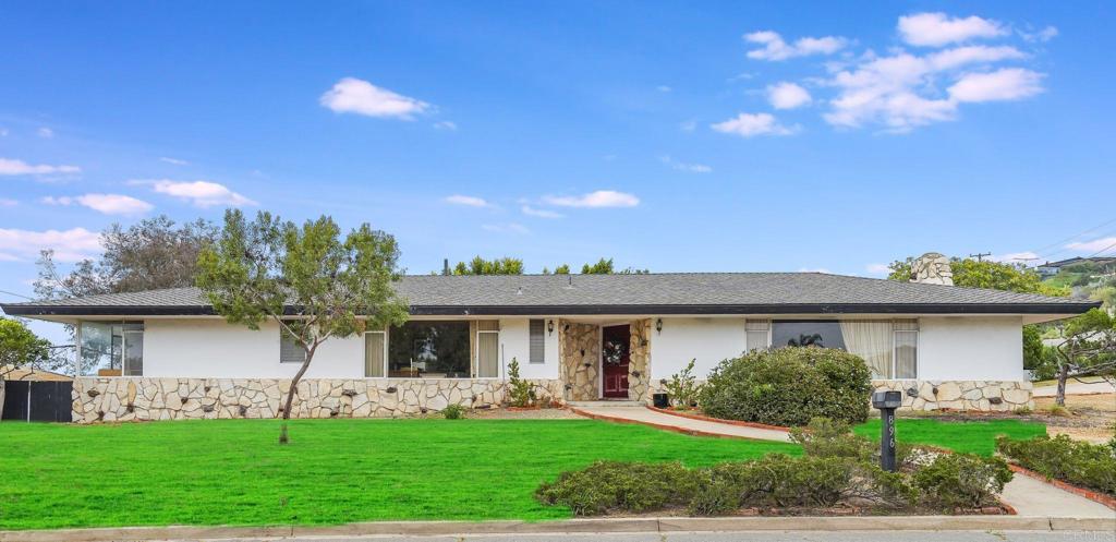 a front view of a house with a garden and a tree