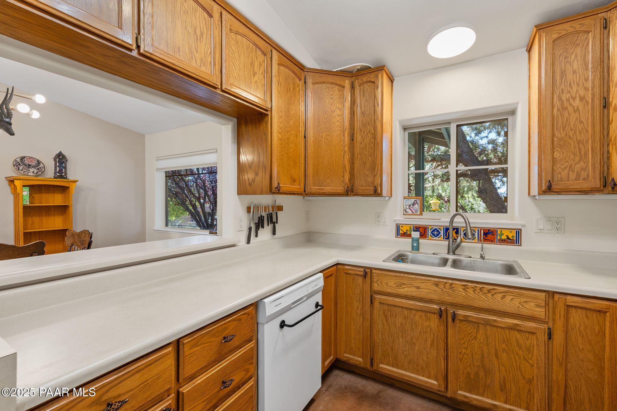 277 Jacob Lane Prescott, AZ 86303 - Photo 10 of 38 a kitchen with stainless steel appliances granite countertop a sink a stove cabinets counter space and a window