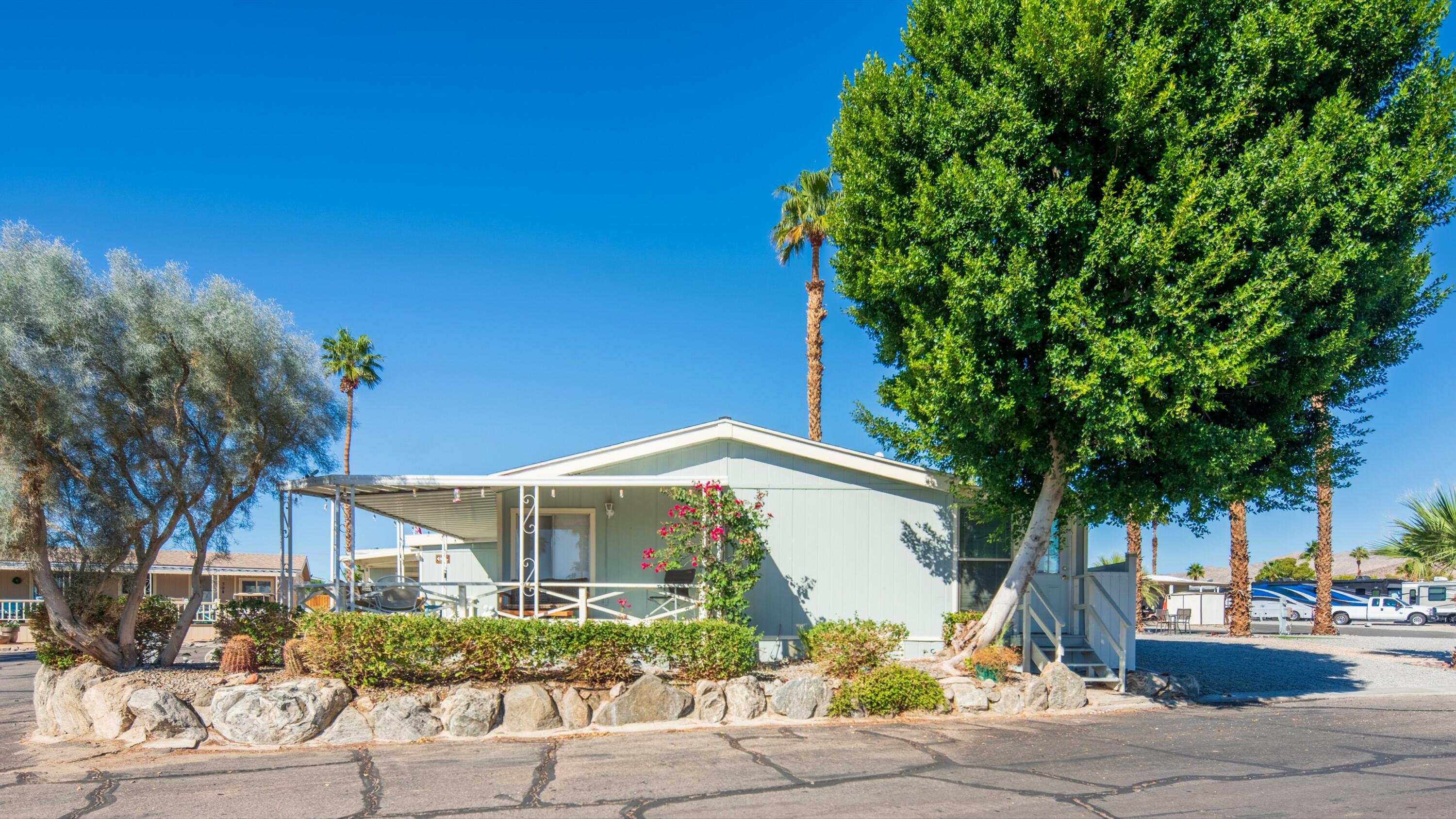 74711 Dillon Road, Unit 392 Desert Hot Springs, CA 92241 - Photo 3 of 46 a front view of a house with a garden