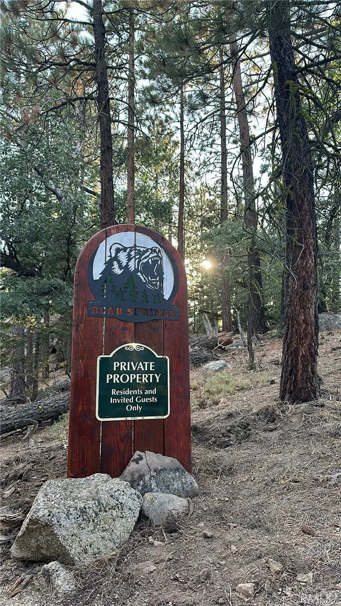 a sign that is sitting in front of a tree