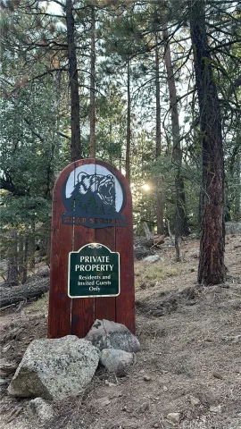 a sign that is sitting in front of a tree