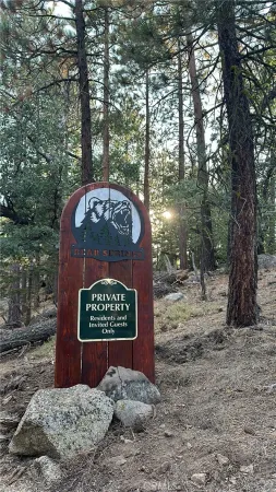 a sign that is sitting in front of a tree