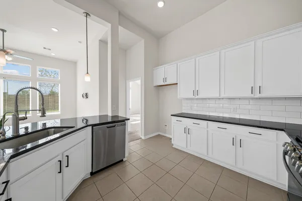 a kitchen with granite countertop white cabinets and a sink