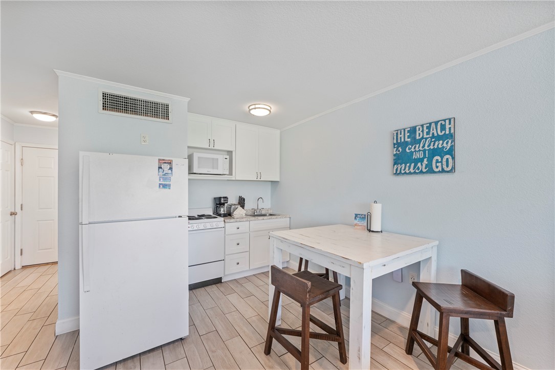 800 Beach Access Road, Unit 111 Port Aransas, TX 78373 - Photo 9 of 30 a kitchen with a refrigerator a stove a sink and a refrigerator