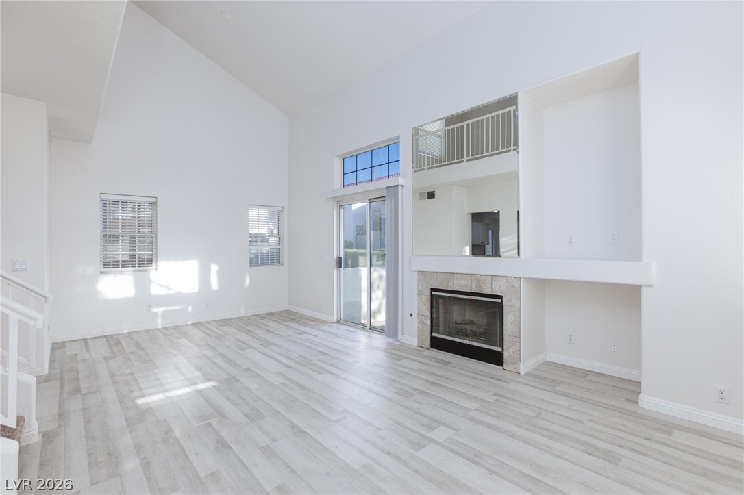 2246 Ramsgate Drive Henderson, NV 89074 - Photo 5 of 36 A spacious living room features soaring ceilings and an elegant fireplace with a tiled surround.
