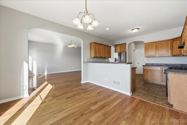 a kitchen with granite countertop a stove a sink and a refrigerator