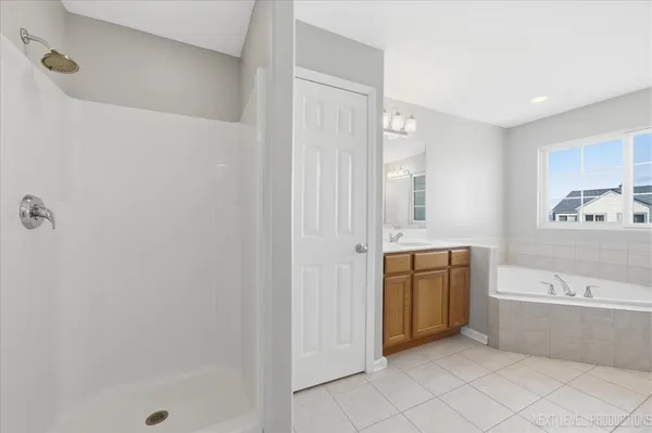 a bathroom with a tub sink and mirror