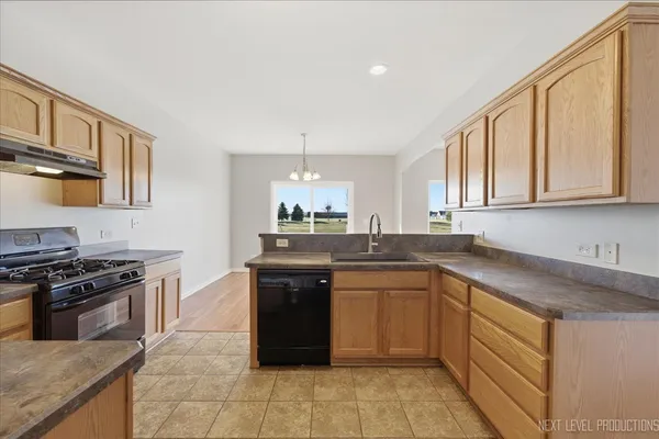 a kitchen with a sink stove top oven and cabinets