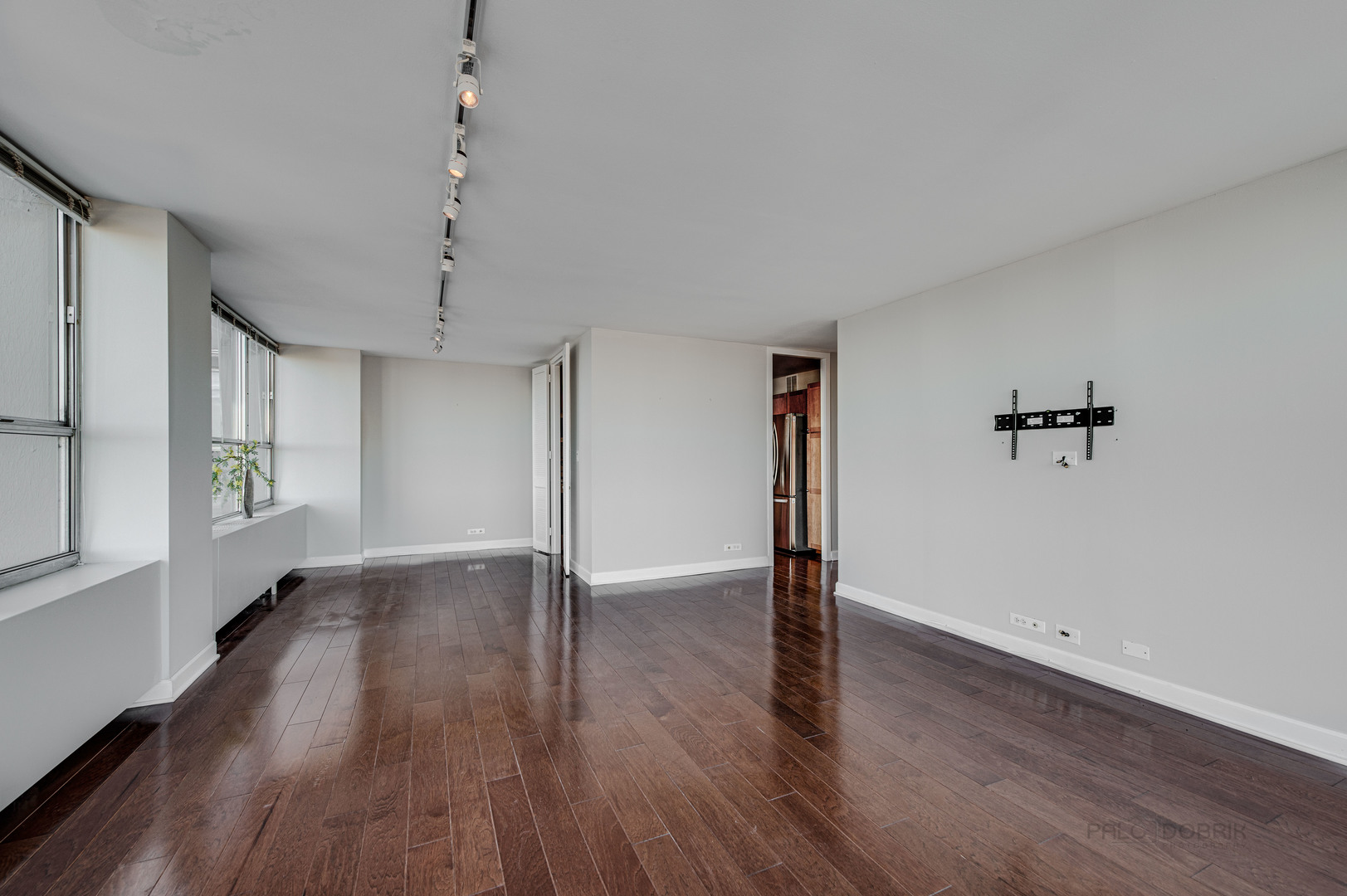 655 West Irving Park Road, Unit 1110 Chicago, IL 60613 - Photo 19 of 30 an empty room with wooden floor chandelier and windows