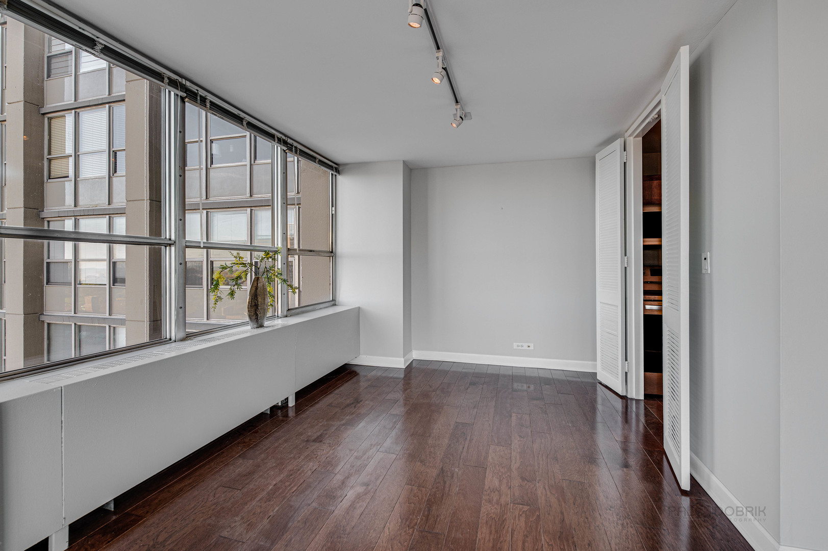 655 West Irving Park Road, Unit 1110 Chicago, IL 60613 - Photo 21 of 30 a view of an empty room with wooden floor and a window