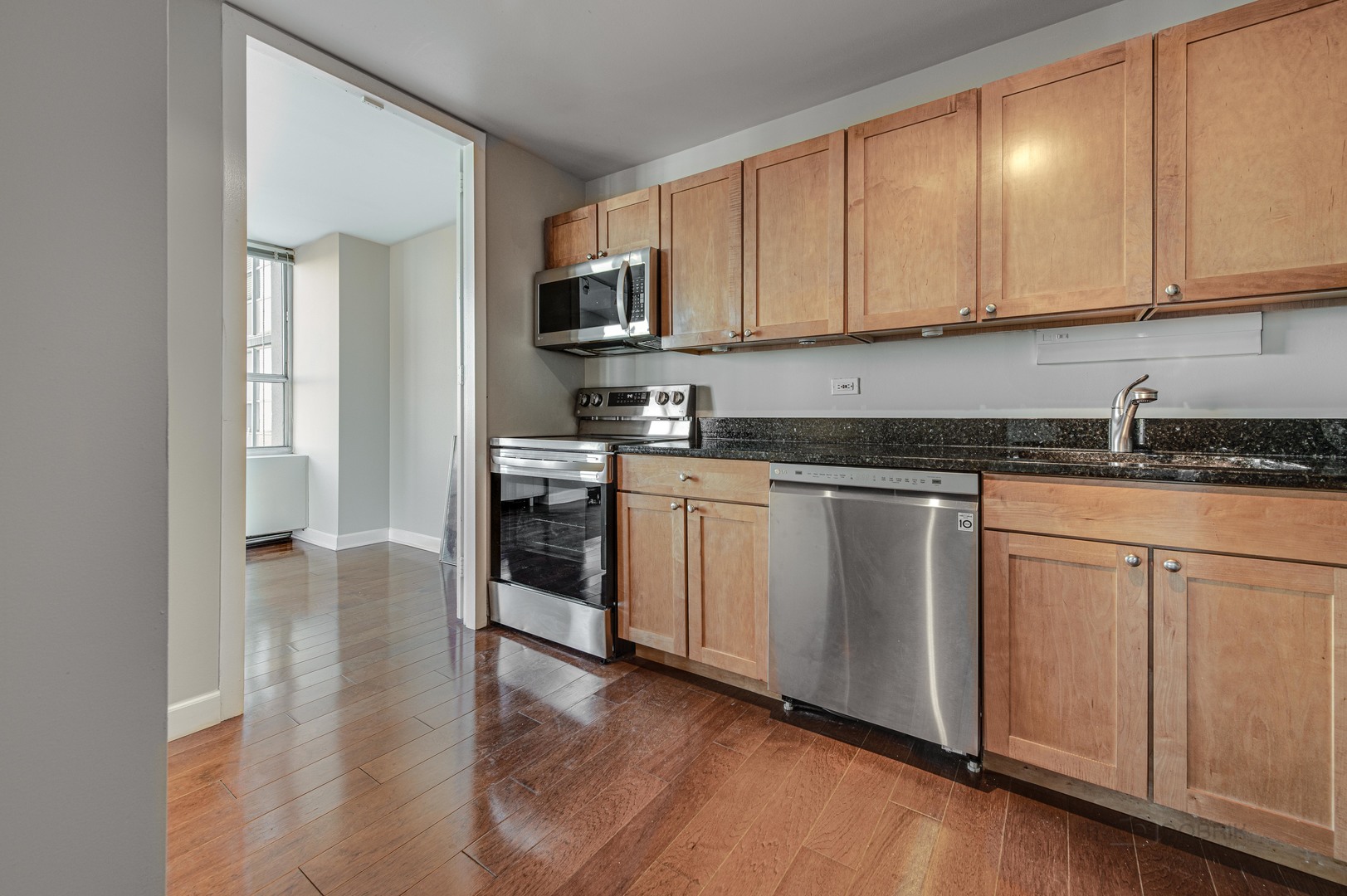 655 West Irving Park Road, Unit 1110 Chicago, IL 60613 - Photo 24 of 30 a kitchen with stainless steel appliances granite countertop a stove a sink and white cabinets