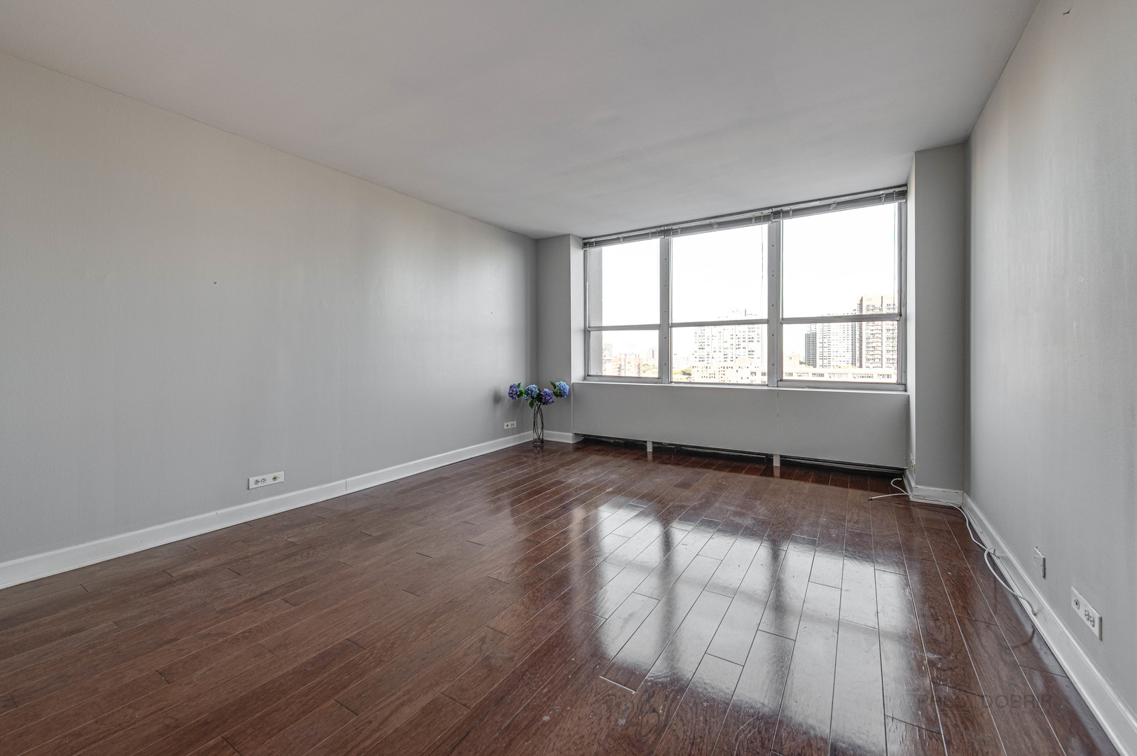655 West Irving Park Road, Unit 1110 Chicago, IL 60613 - Photo 25 of 30 an empty room with wooden floor and windows
