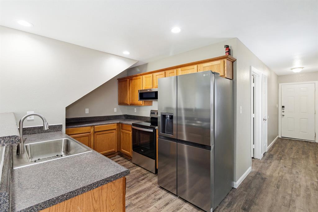 a kitchen with stainless steel appliances granite countertop a refrigerator a sink and a stove