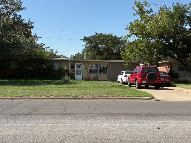 2703 66th Street Lubbock, TX 79413 - Photo 1 of 8 a front view of a house with a garden and trees
