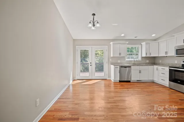 a large kitchen with cabinets and wooden floor