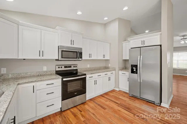 a kitchen with white cabinets and stainless steel appliances