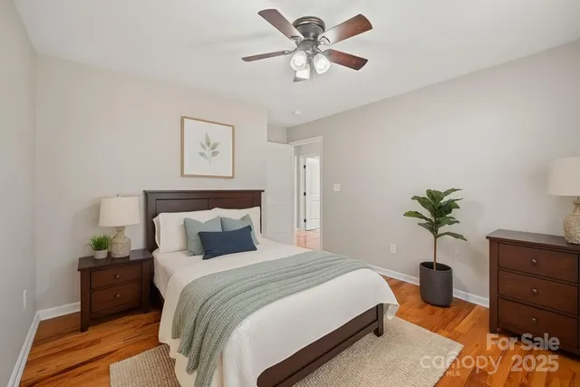 a bedroom with a bed potted plant and a chandelier
