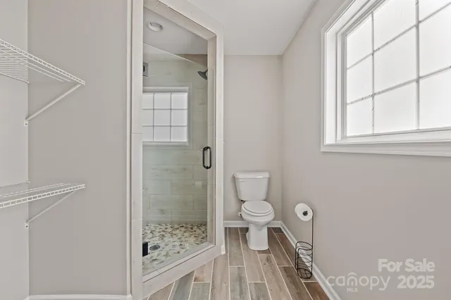 a bathroom with a granite countertop toilet a sink and shower
