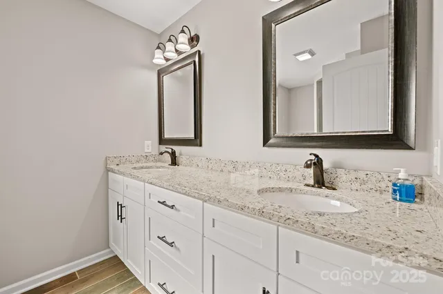 a bathroom with double sink and a mirror
