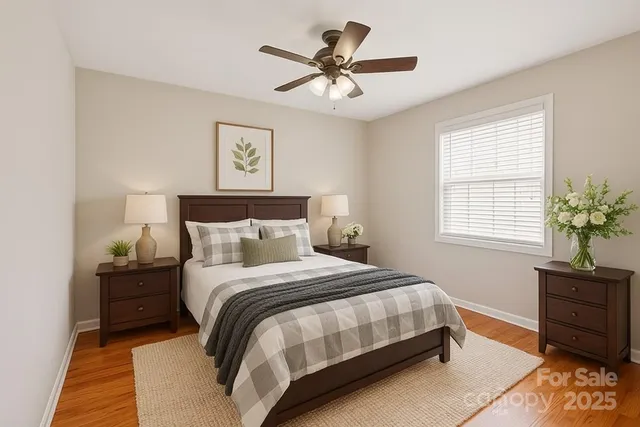 a bedroom with a bed and a potted plant on the dresser