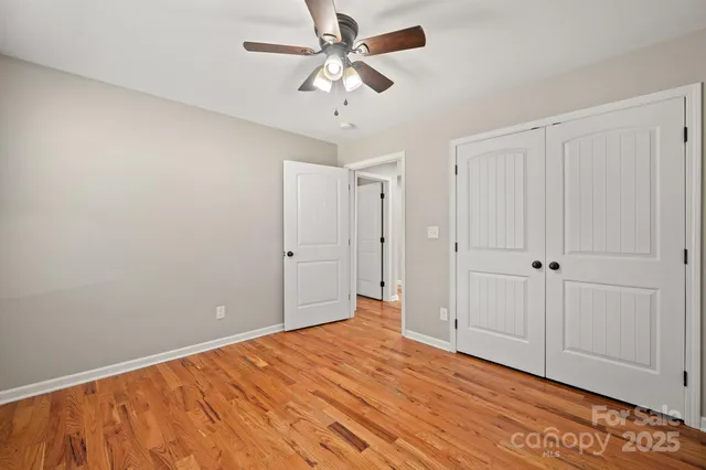 a view of empty room with window and ceiling fan
