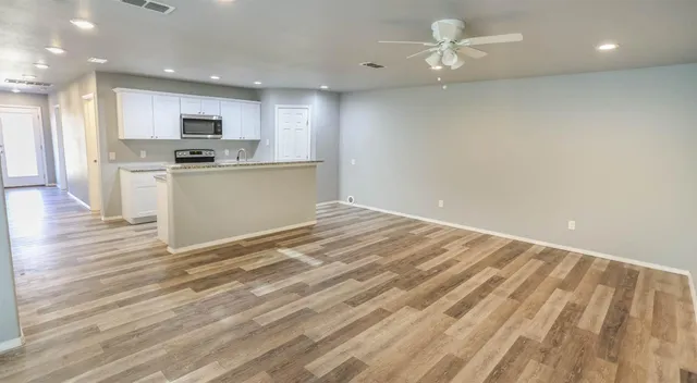 a view of kitchen with granite countertop cabinets and refrigerator