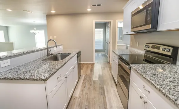 a kitchen with stainless steel appliances granite countertop a sink stove and refrigerator