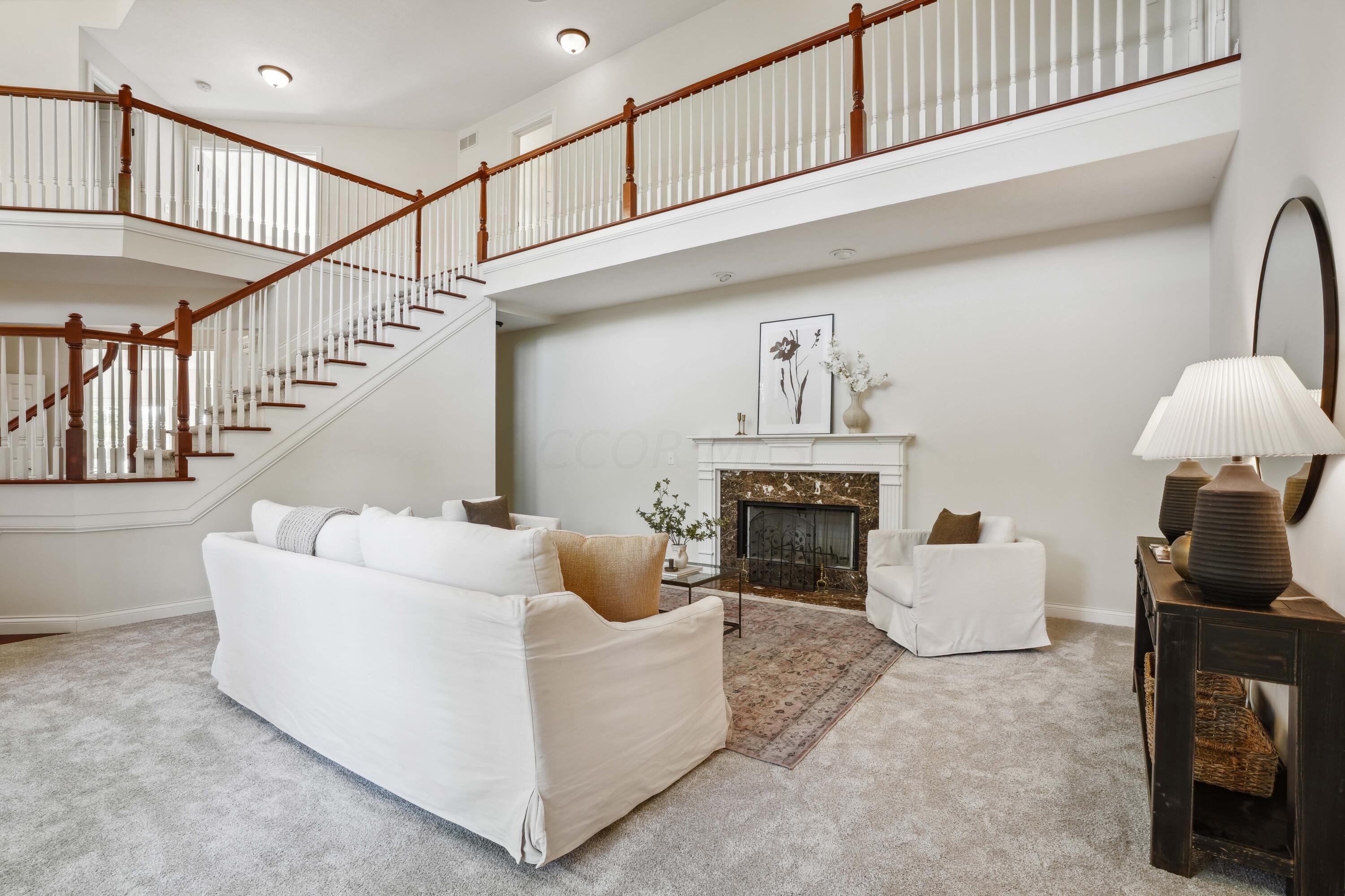10403 Liberty Road Powell, OH 43065 - Photo 7 of 76 Bright and airy Two Story Great Room with marble gas fireplace, freshly painted & new carpet in July 2024! French doors to front deck overlooking the pond!