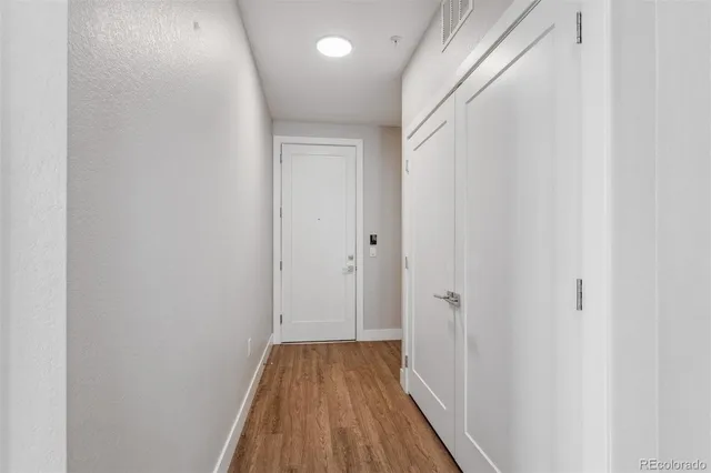 a view of a hallway with wooden floor