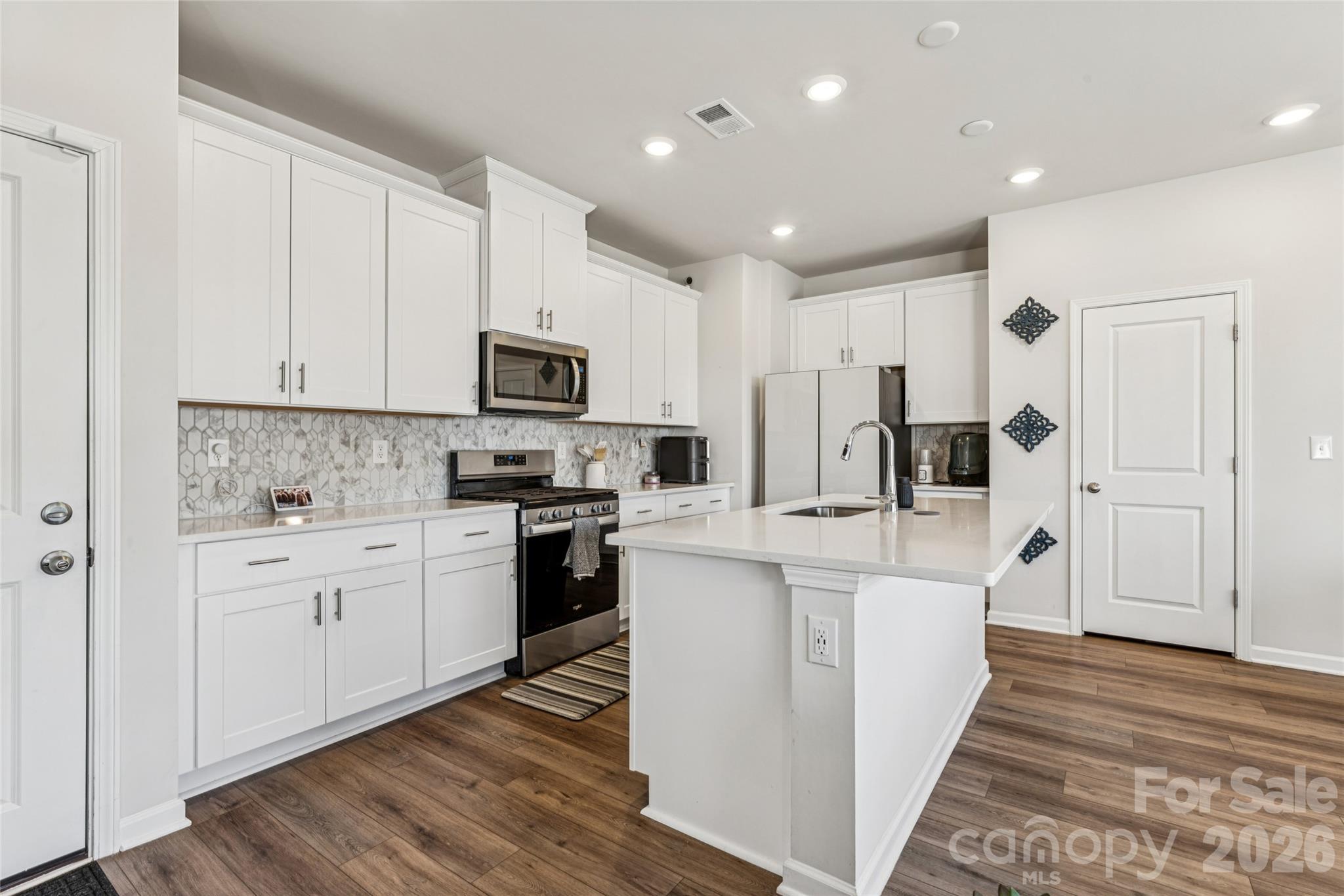 309 Olympia Way York, SC 29745 - Photo 14 of 46 a kitchen with white cabinets and stainless steel appliances